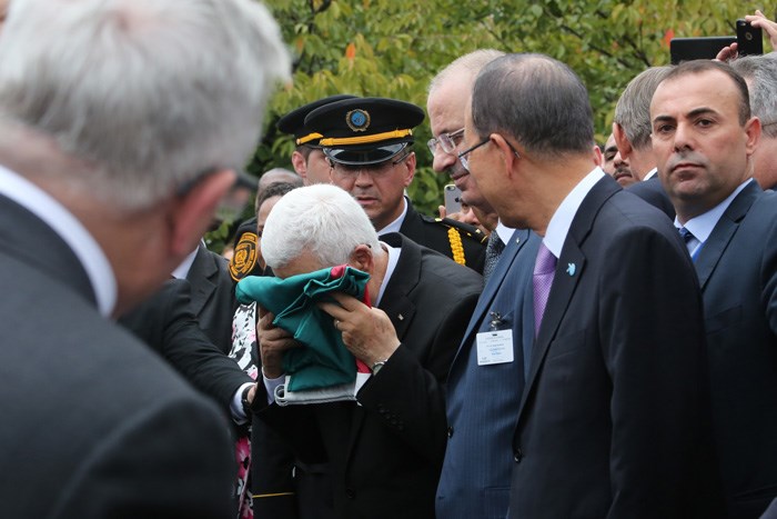 الرئيس محمود عباس يقبّل علم فلسطين قبل رفعه لأول مرة بمقر الأمم المتحدة في نيويورك عام 2015